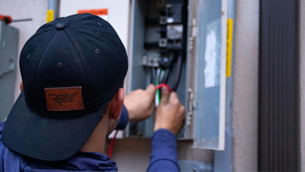 électricien qui répare un tableau électrique